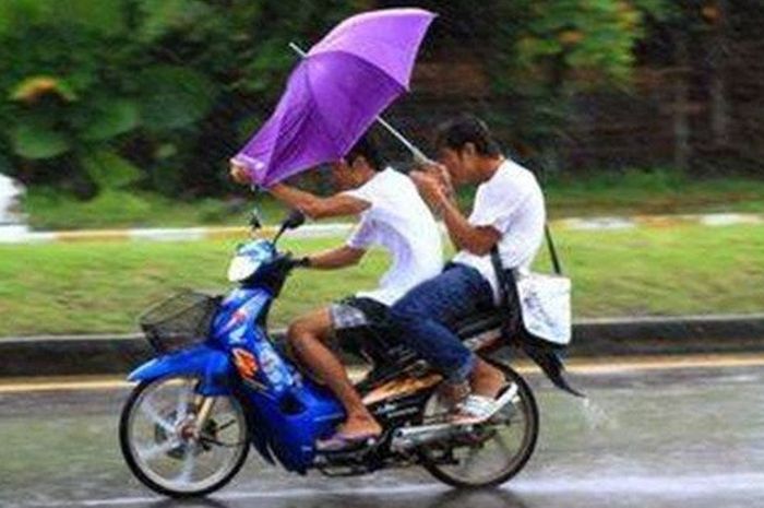 Ilustrasi membawa payung saat berkendara