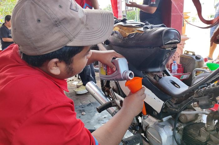Ilustrasi proses ganti oli gratis dari Pertamina Lubricants untuk para korban banjir Jabodetabek