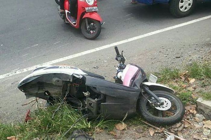 Motor matik Yamaha Fino tergeletak di pinggir jalan dengan kondisi arm belakang putus