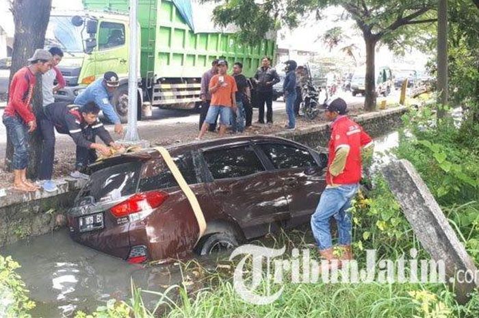 Proses evakuasi honda Mobilio W 1879 EC warna merah maroon milik Khoirus Sobah warga Desa Mengare, Kecamatan Bungah di dalam parit samping jalan raya Tambakberas, Kecamatan Cerme, Jum'at (6/3/2020).  