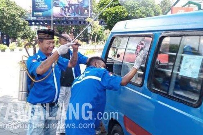 Paguyuban sopir angkutan kota (angkot) di Kota Malang melakukan penyemprotan disinfektan secara mandiri ke mobil yang dioperasikan.  