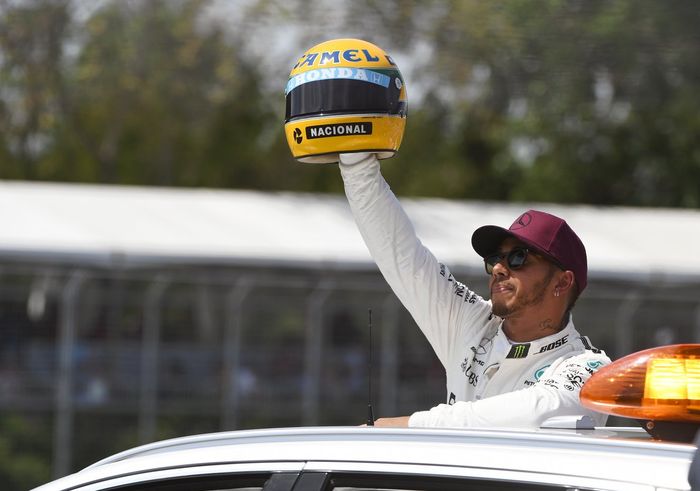 Lewis Hamilton dan replika helm Ayrton Senna dari keluarga Senna setelah menyamakan rekor pole positionnya ke-65 di GP F1 Kanada 2017