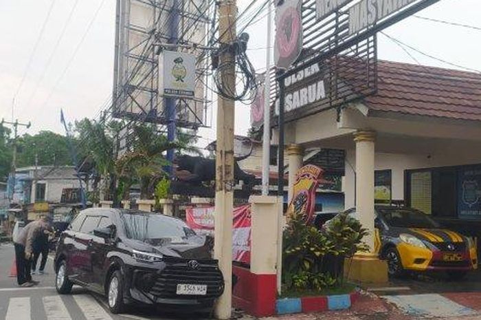 Toyota Avanza nyangkut di tiang listrik yang berada di depan pos polisi