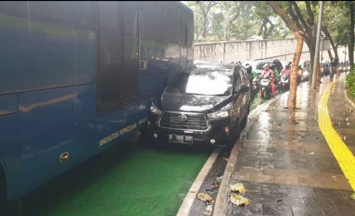 Toyota Kijang Innova kejepit Bus TransJakarta dan trotoar akibat maksa nyalip di Jl Jenderal Sudirman, arah bundaran Senayan, Semanggi, Jakarta Selatan