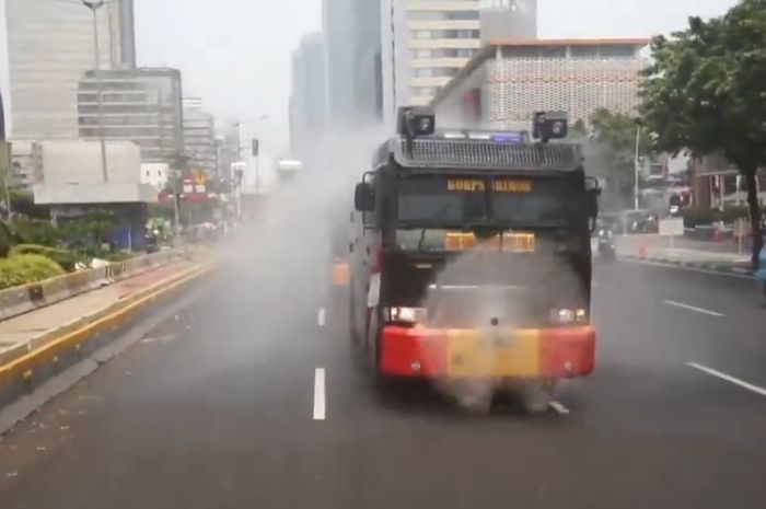 Mobil water canon milik Polda Metro Jaya tengah menyirami jalan untuk kurangi polusi udara