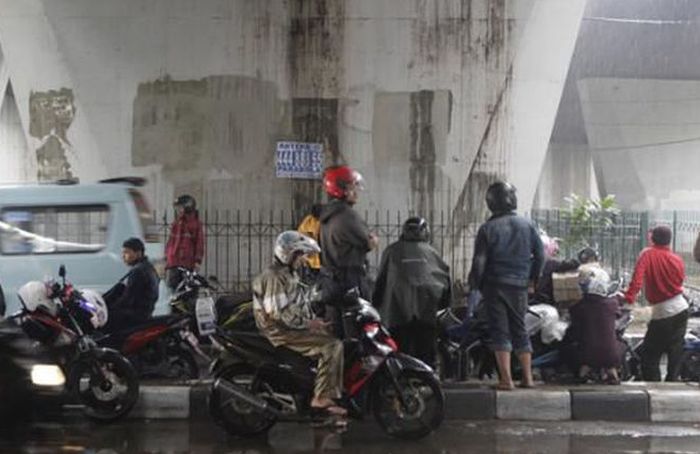 Ilustrasi pengendara berteduh di bawah jembatan