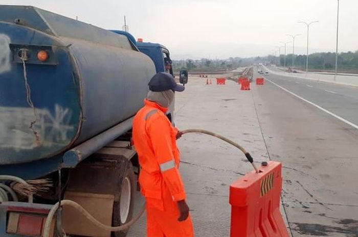 Water barrier yang sedang diisi oleh petugas 