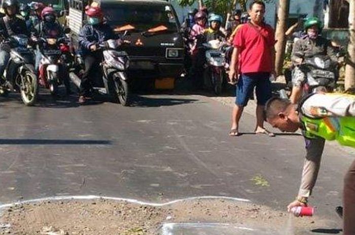 Polisi saat melakukan olah TKP kecelakaan maut pemotor Honda Scoopy dilindas truk tronton, di Jalan Raya Tambak Kemerakan, Krian, Sidoarjo, Kamis (11/7/2019).  