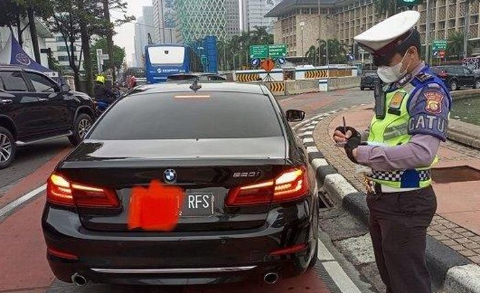 (lustrasi) Polisi menilang BMW 520i berpelat nomor RFS akibat melanggar ganjil genap di DKI Jakarta