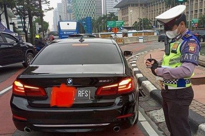 (lustrasi) Polisi menilang BMW 520i berpelat nomor RFS akibat melanggar ganjil genap di DKI Jakarta