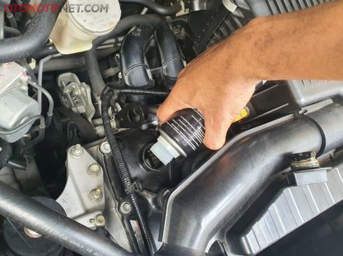 Ilustrasi pemakaian engine flush sebelum menguras oli mesin.