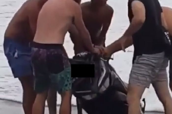 para Bule Bali saat mengangkat motor rental yang diceburkan ke dalam laut