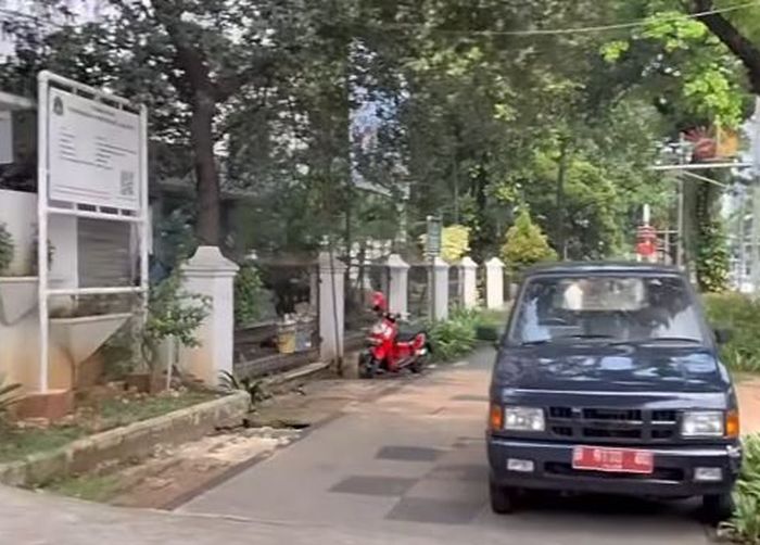 Isuzu Panther dinas pelat merah B 9110 QU parkir di atas trotoar jalan, tepat di depan kantor Satpol PP DKI Jakarta, Kebon Sirih, Jakarta Pusat