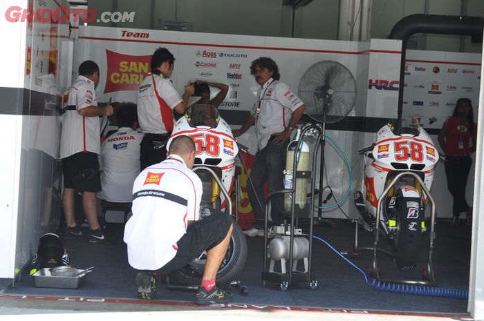 Kru tim San Carlo Gresini mempersiapkan motor Honda RC212V yang dipakai Marco Simoncelli di MotoGP Malaysia 2011, ayahnya Paolo Simoncelli berdiri di belakang