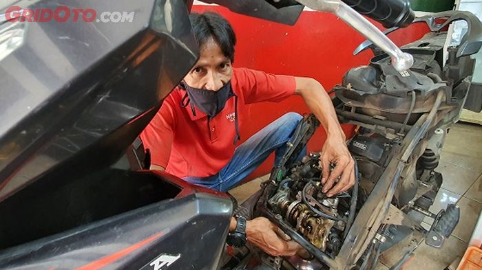 Muhammad Faiz, owner D'kutic yang lagi menangani servis besar motor matic