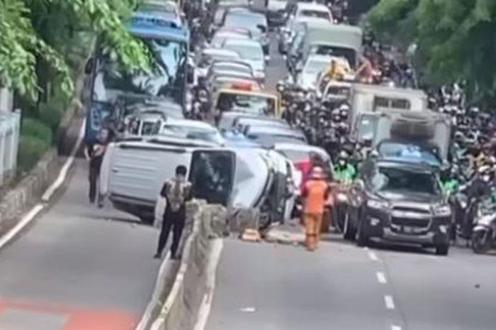 Daihatsuu Terios terguling setelah tabrak beton separator busway di Jl Sultan Iskandar Muda, Kebayoran Lama, Jakarta Selatan
