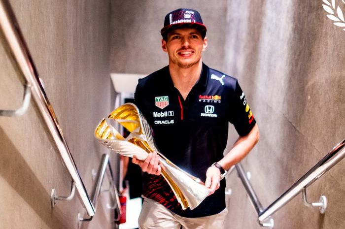 Max Verstappen dengan trofi kemenangan di F1 Abu Dhabi 2021 saat merebut gelar juara dunia F1 2021
