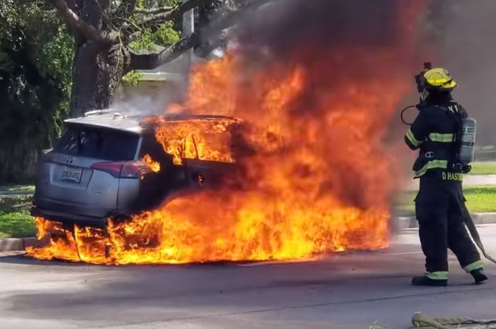 Petugas pemadam kebakaran berusaha memadamkan api dari Toyota RAV4