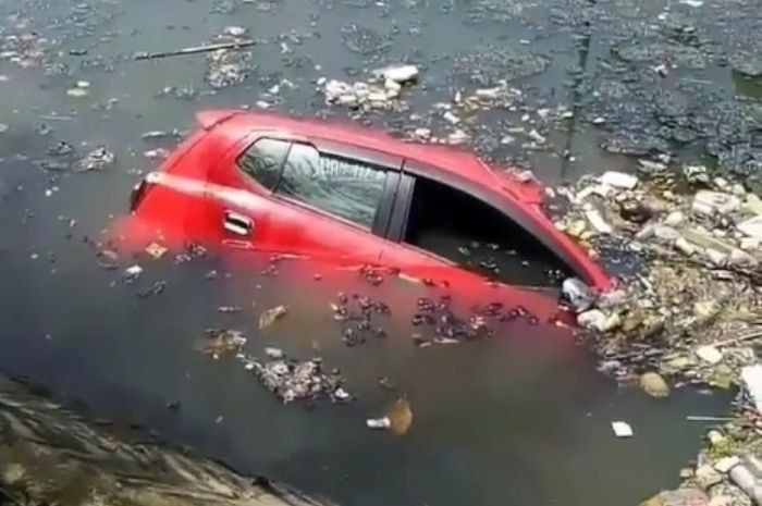 Mobil merah mengambang bareng sampah di saluran air dikira ada yang buang ke kali