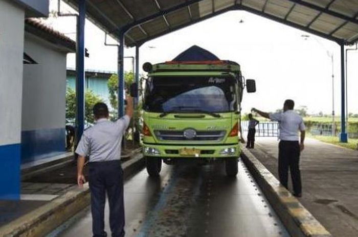 Ilustrasi petugas melakukan penimbangan truk di jembatan timbang