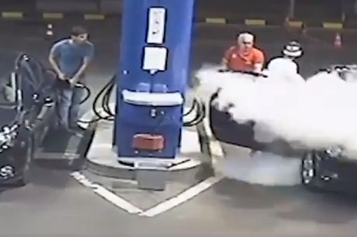 Pengendara yang disemprot oleh petugas karena merokok di pom bensin