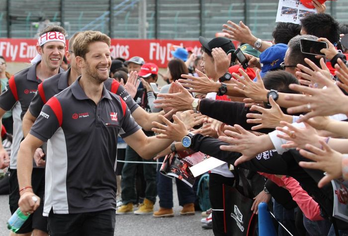 Pembalap tim Haas, Romain Grosjean menyapa para penggemar yang datang ke di sirkuit Suzuka hari Kamis (5/10/2017)